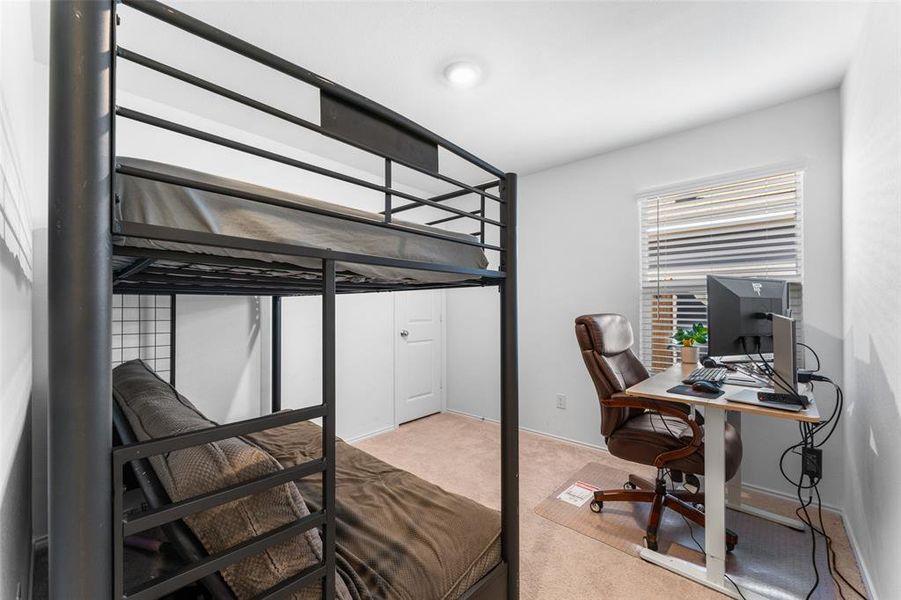 Bedroom with light carpet and an office area Bedroom with light carpet and an office area