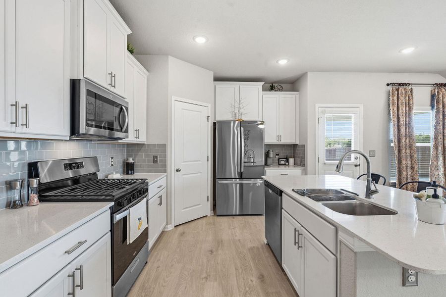 Kitchen with stainless steel appliances, light wood-style flooring, white cabinetry, light stone counters, and recessed lighting Kitchen with stainless steel appliances, light wood-style flooring, white cabinetry, light stone counters, and recessed lighting