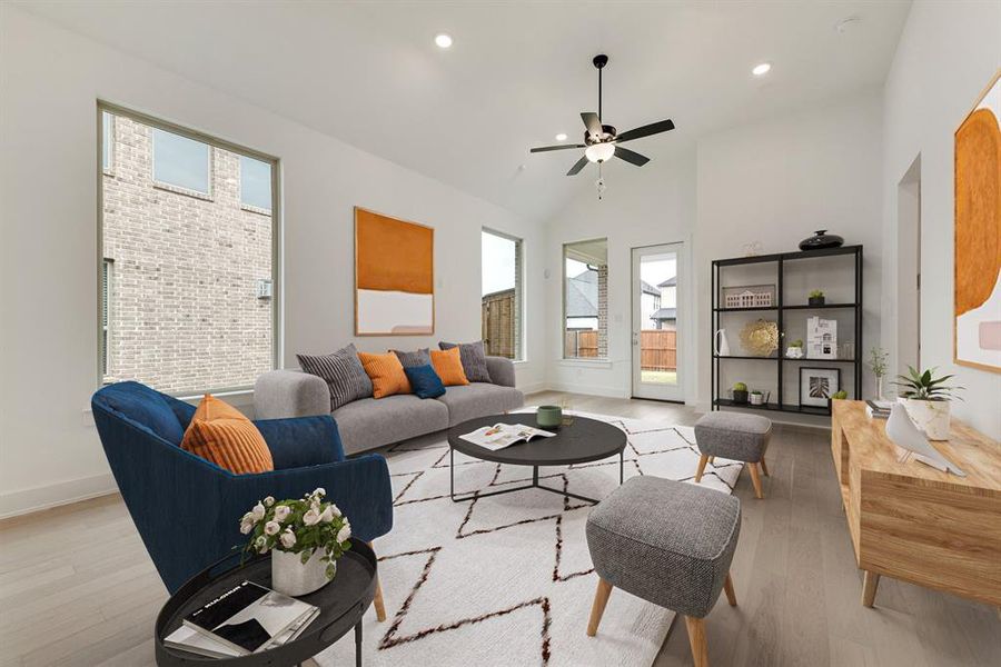 Living area with wood finished floors, recessed lighting, ceiling fan, and high vaulted ceiling Living area with wood finished floors, recessed lighting, ceiling fan, and high vaulted ceiling