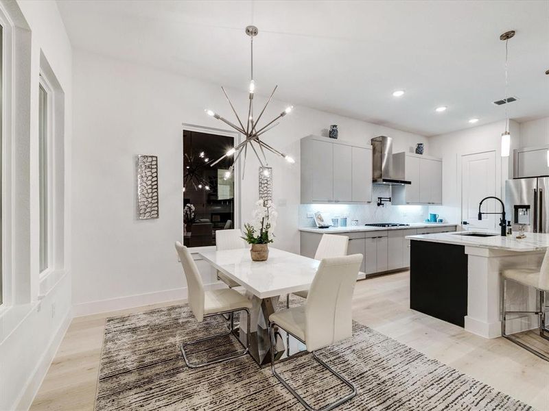 Dining room featuring light wood finished floors, a chandelier, and recessed lighting Dining room featuring light wood finished floors, a chandelier, and recessed lighting