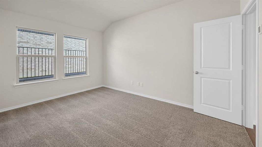 Unfurnished room with vaulted ceiling and carpet floors