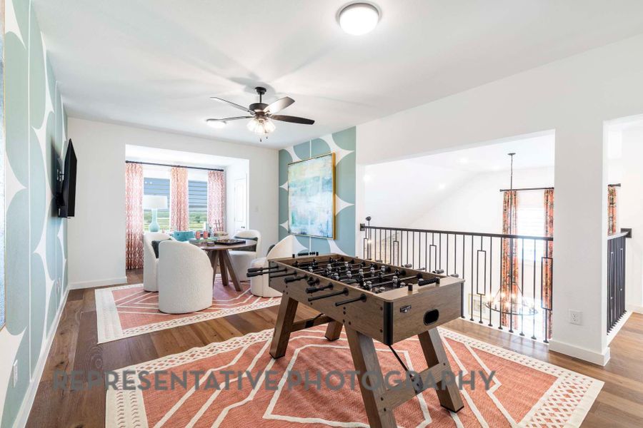 Playroom with a ceiling fan, baseboards, and wood finished floors Playroom with a ceiling fan, baseboards, and wood finished floors