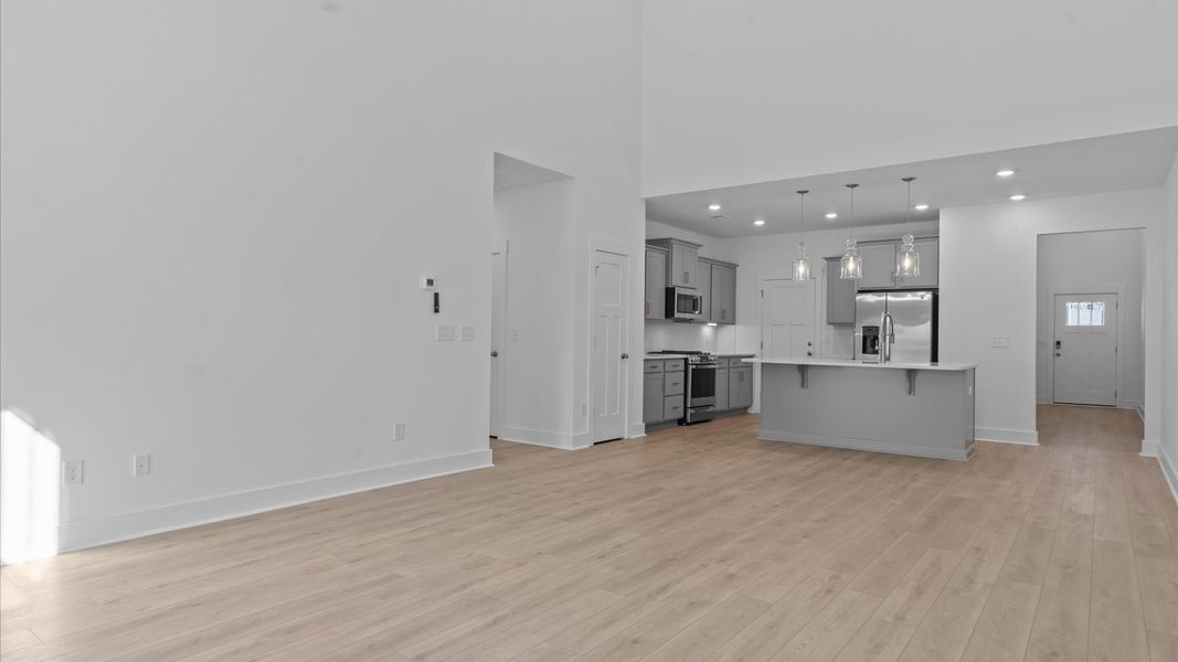 Spacious and stylish family room with two-story ceilings that create a bright and open atmosphere