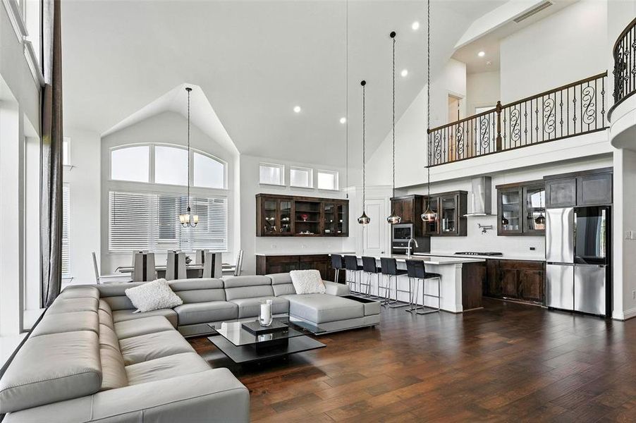 Living room with high vaulted ceiling, dark wood-style floors, recessed lighting, and a chandelier
