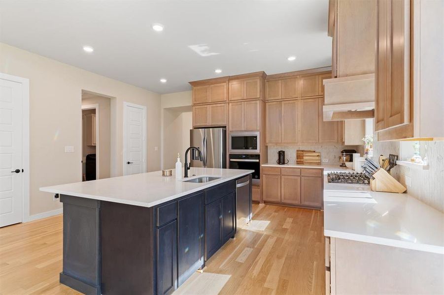 Quartz countertops, stacked cabinetry, ss appliances, and backsplash to the ceiling
