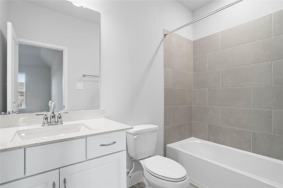 This ensuite secondary bathroom features a modern vanity, tub/shower combination with tile surround, and neutral finishes. This ensuite secondary bathroom features a modern vanity, tub/shower combination with tile surround, and neutral finishes.