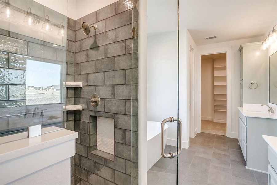 Bathroom featuring two vanities, a soaking tub, walk in shower, and a spacious closet Bathroom featuring two vanities, a soaking tub, walk in shower, and a spacious closet
