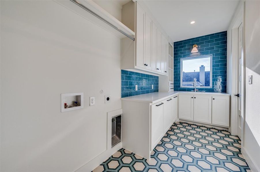 Clothes washing area with washer hookup, sink, cabinets, and electric dryer hookup