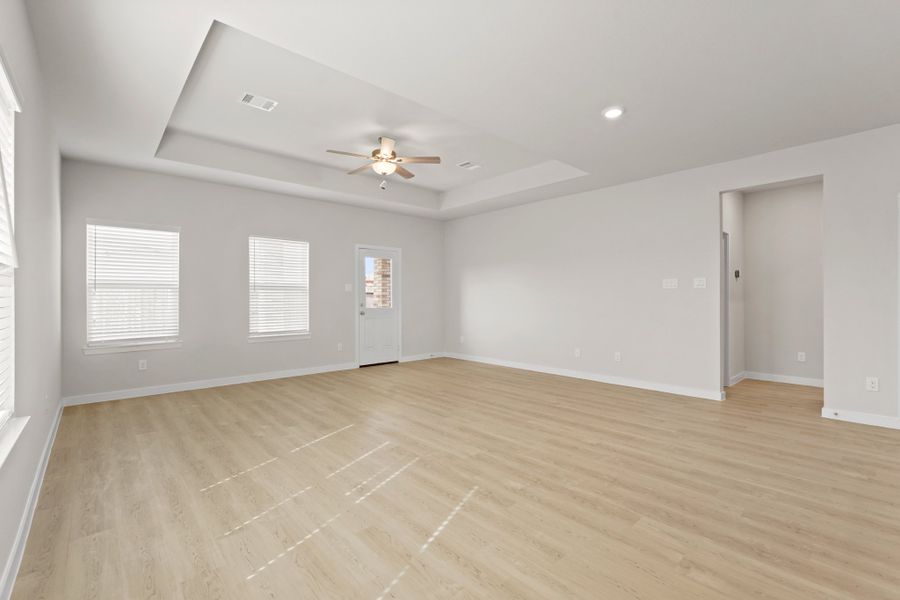 A room with a wood floor and a ceiling fan. A room with a wood floor and a ceiling fan.