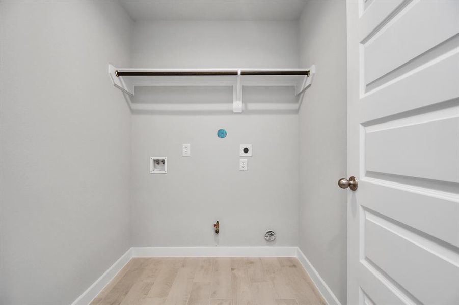 A perfect blend of functionality and comfort. Laundry room, thoughtfully equipped with shelving for effortless organization. Both gas and electric dryer connections available.  Sample photo of completed home with similar floor plan. Actual colors and selections may vary.