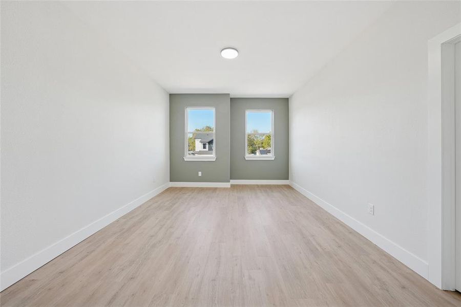Unfurnished room with light wood finished floors and baseboards