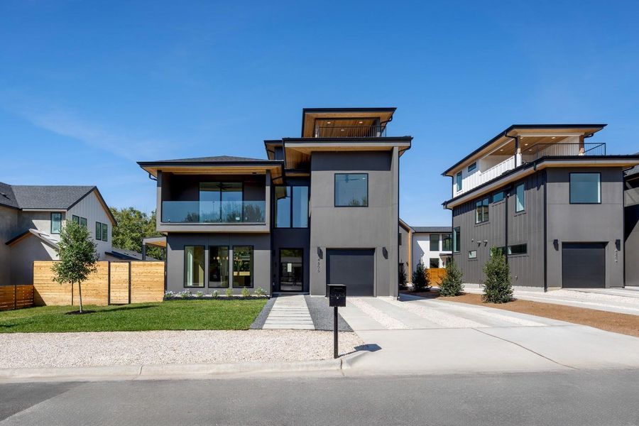 Contemporary home with a balcony, concrete driveway, a front lawn, a garage, and stucco siding Contemporary home with a balcony, concrete driveway, a front lawn, a garage, and stucco siding