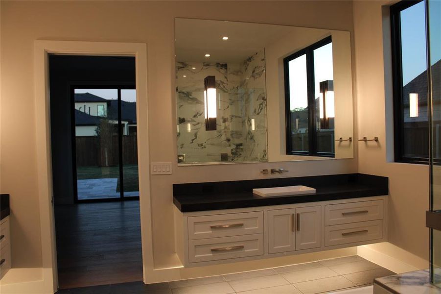 Bathroom with walk in shower, plenty of natural light, vanity, and tile patterned flooring