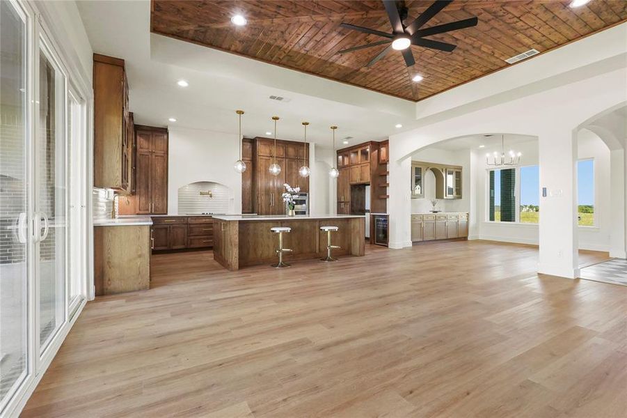 Unfurnished living room with a chandelier, recessed lighting, light wood-style floors, arched walkways, and ceiling fan Unfurnished living room with a chandelier, recessed lighting, light wood-style floors, arched walkways, and ceiling fan