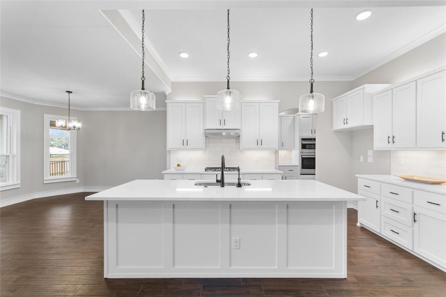 Kitchen with a sink, decorative backsplash, light countertops, crown molding, and white cabinets Kitchen with a sink, decorative backsplash, light countertops, crown molding, and white cabinets