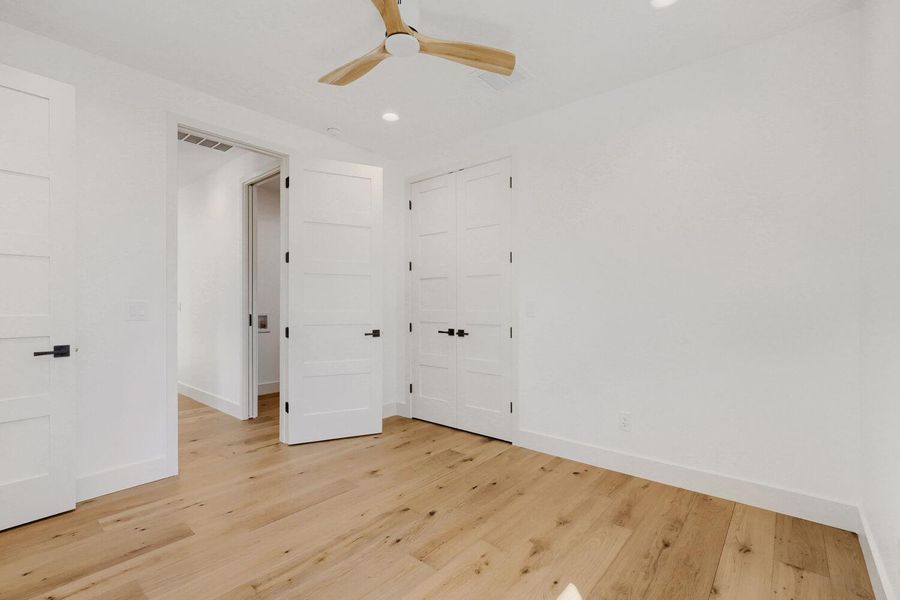 Unfurnished bedroom with light wood-type flooring, a ceiling fan, a closet, and recessed lighting Unfurnished bedroom with light wood-type flooring, a ceiling fan, a closet, and recessed lighting