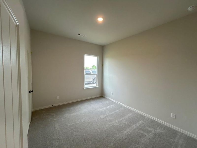 Carpeted room with a single window and recessed lighting