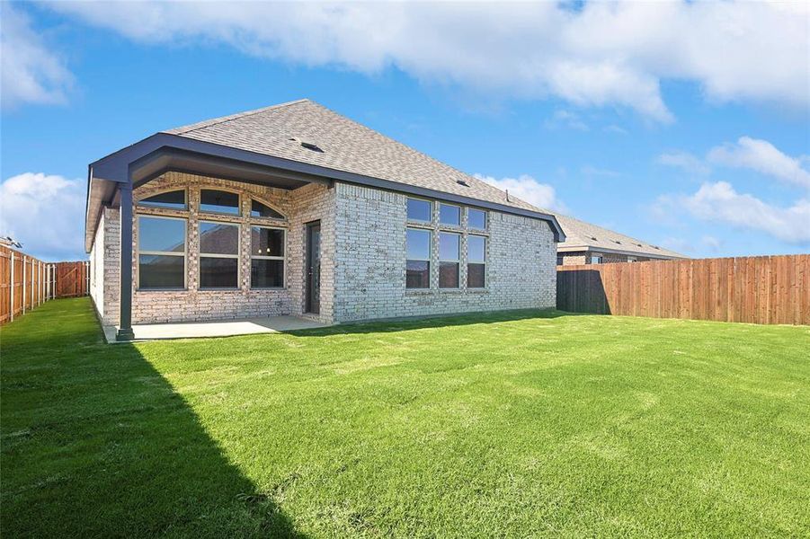 Rear view of property featuring a lawn