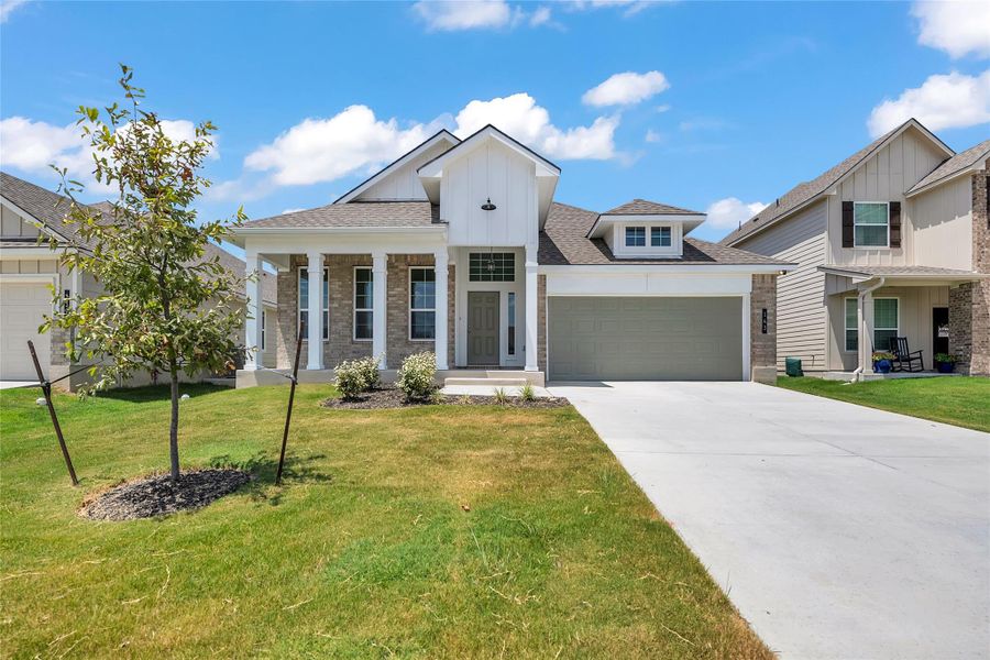 Modern farmhouse with board and batten siding, covered porch, roof with shingles, concrete driveway, and an attached garage Modern farmhouse with board and batten siding, covered porch, roof with shingles, concrete driveway, and an attached garage