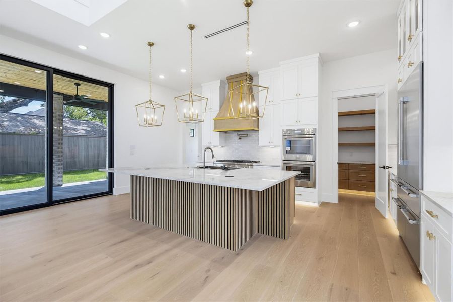 The kitchen is a chef's dream! With natural Taj Mahal countertops and a waterfall sink.