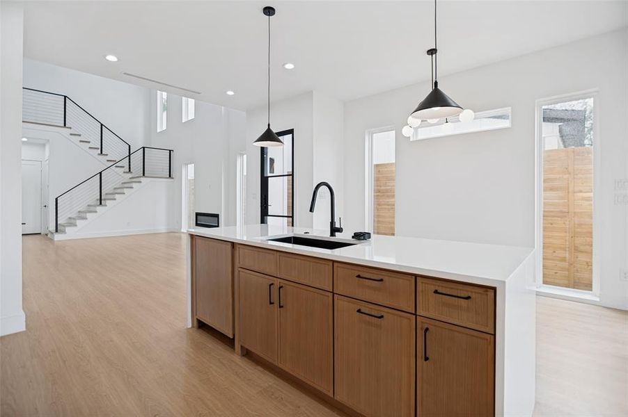 Kitchen island featuring wood-finish cabinetry, a black sink, and a black faucet