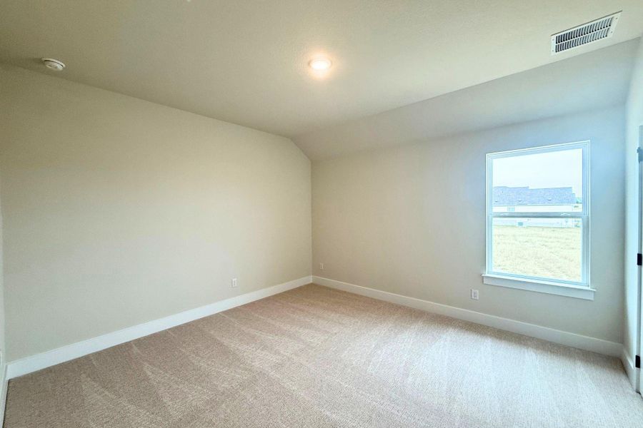 A well-lit bedroom features plush carpeting and a generous window, ready for your personal touch. A well-lit bedroom features plush carpeting and a generous window, ready for your personal touch.