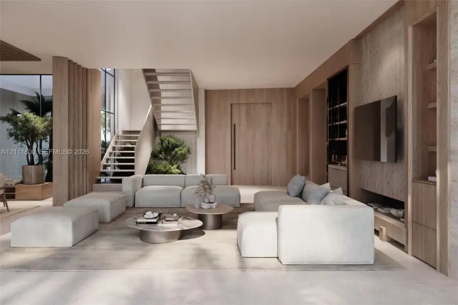 Open-concept living space featuring wood-paneled walls, floor-to-ceiling custom built-in cabinetry, an open-riser wood staircase, and expansive windows