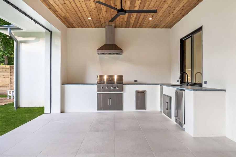 View of patio with ceiling fan, sink, grilling area, and exterior kitchen with coyote appliances