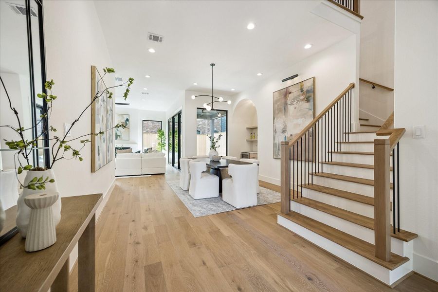 Wood railing with iron balusters and wide plank wood flooring and designer lighting. Wood railing with iron balusters and wide plank wood flooring and designer lighting.