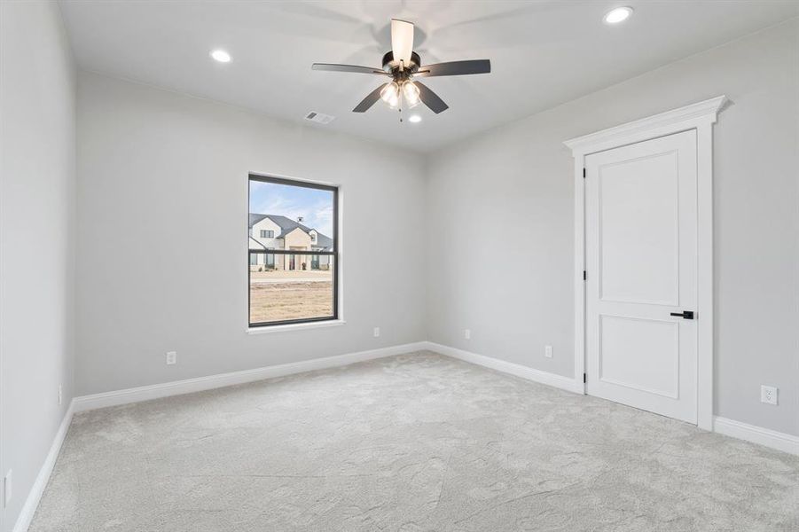 Spare room featuring light carpet and ceiling fan