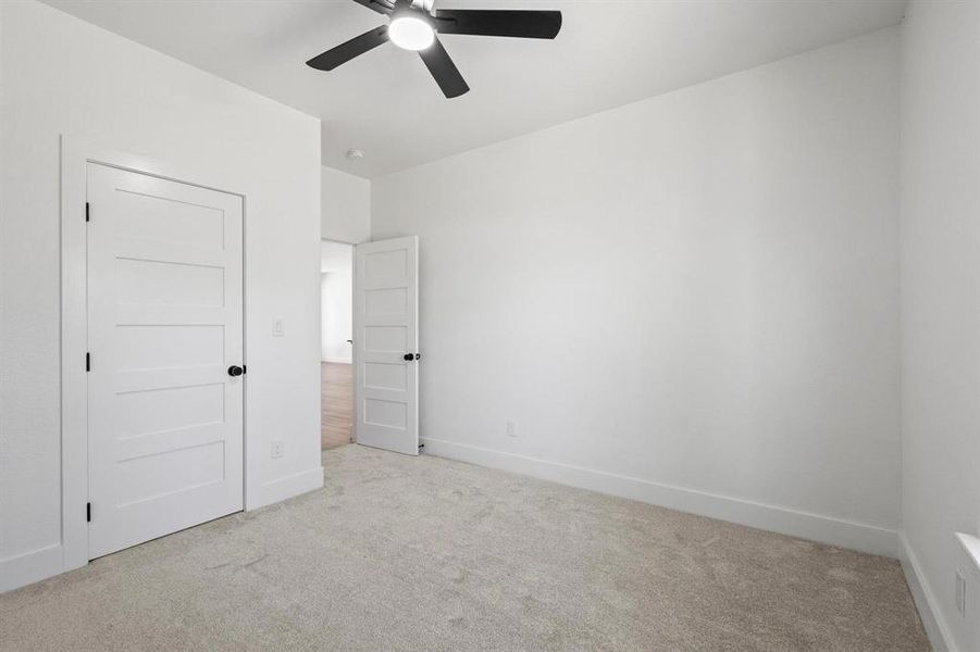 Unfurnished bedroom featuring light carpet and ceiling fan