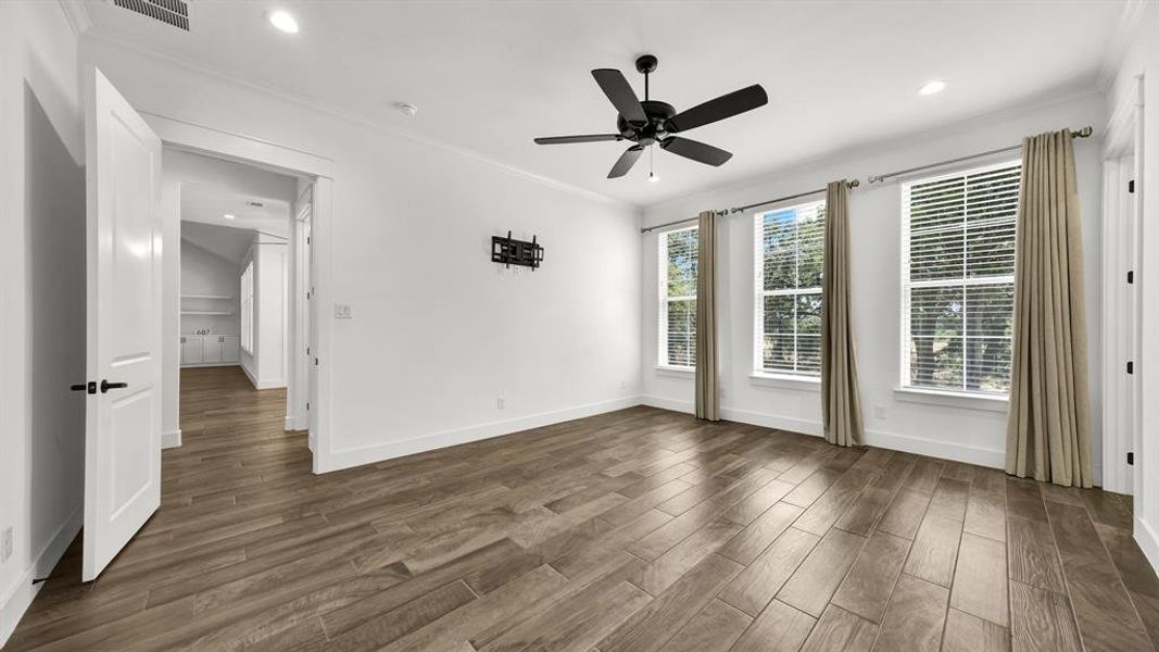 Empty room with ceiling fan, ornamental molding, and hardwood / wood-style flooring