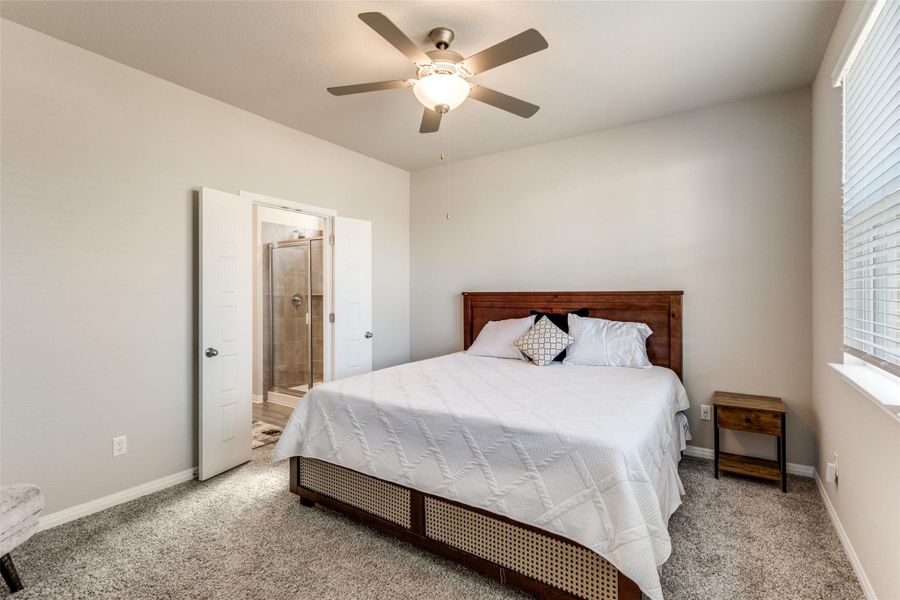 Carpeted bedroom with a ceiling fan and ensuite bathroom