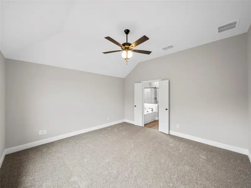 Unfurnished bedroom with visible vents, baseboards, light carpet, and lofted ceiling Unfurnished bedroom with visible vents, baseboards, light carpet, and lofted ceiling