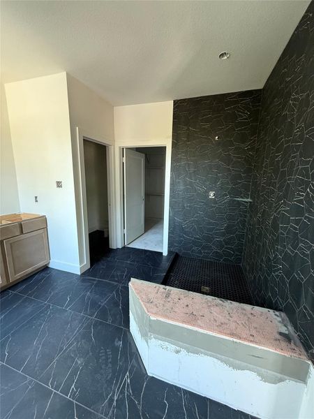 This striking shower features Perpetuo Hex Matte Black wall tile, a black hex mosaic shower floor, and elegant champagne-bronze fixtures by Delta. The dramatic black-on-black design is elevated by clean grout lines and premium materials — offering a bold, refined finish that defines the home’s contemporary elegance. This striking shower features Perpetuo Hex Matte Black wall tile, a black hex mosaic shower floor, and elegant champagne-bronze fixtures by Delta. The dramatic black-on-black design is elevated by clean grout lines and premium materials — offering a bold, refined finish that defines the home’s contemporary elegance.