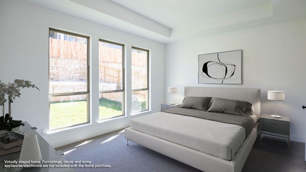 Carpeted bedroom with a raised ceiling