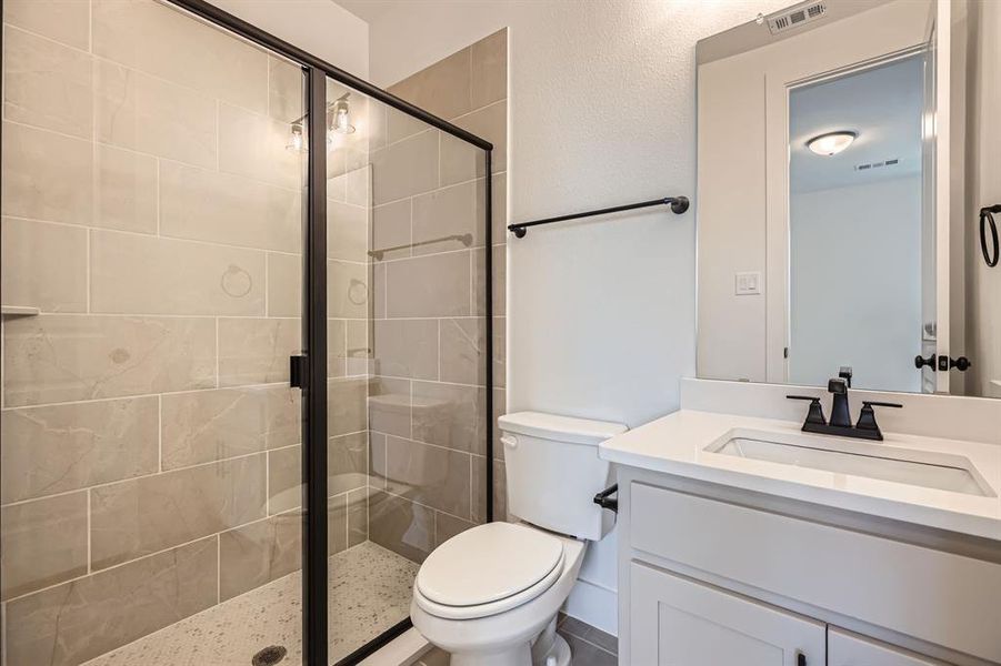 Full bathroom featuring toilet, vanity, and a stall shower Full bathroom featuring toilet, vanity, and a stall shower