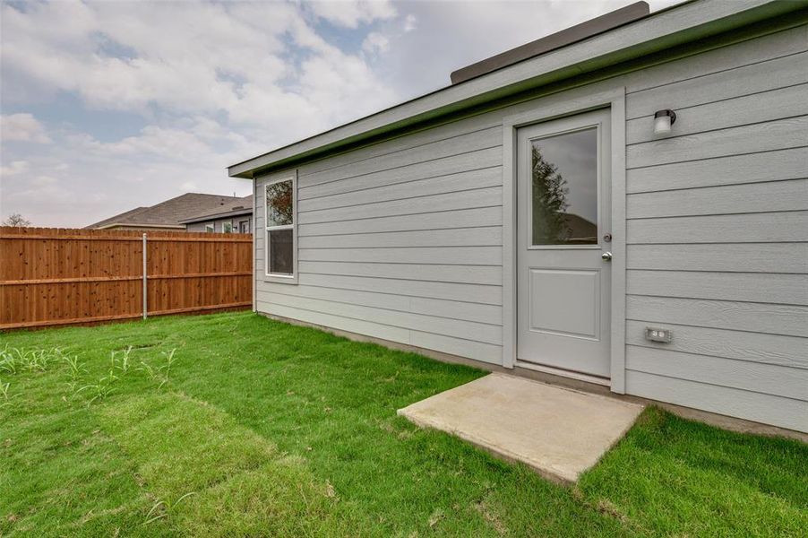 View of exterior entry with a lawn