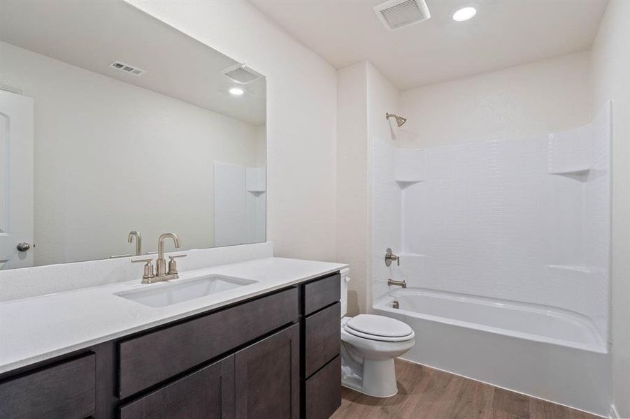 Full bathroom with shower combination, wood-style flooring, vanity, and toilet