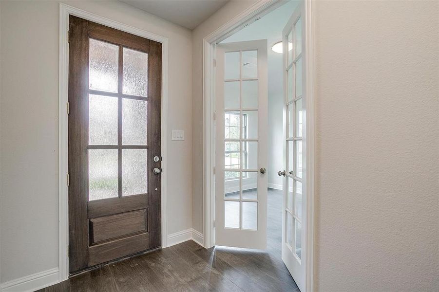 Doorway with dark hardwood / wood-style floors and french doors