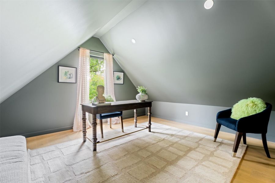 Home office featuring wood finished floors and vaulted ceiling