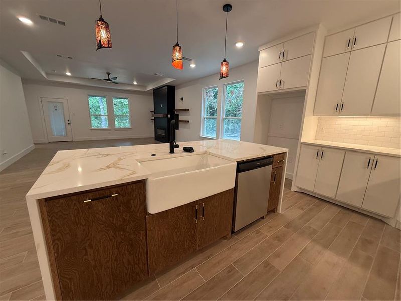 Kitchen featuring wood tiled floors, plenty of natural light, light stone counters, and recessed lighting Kitchen featuring wood tiled floors, plenty of natural light, light stone counters, and recessed lighting