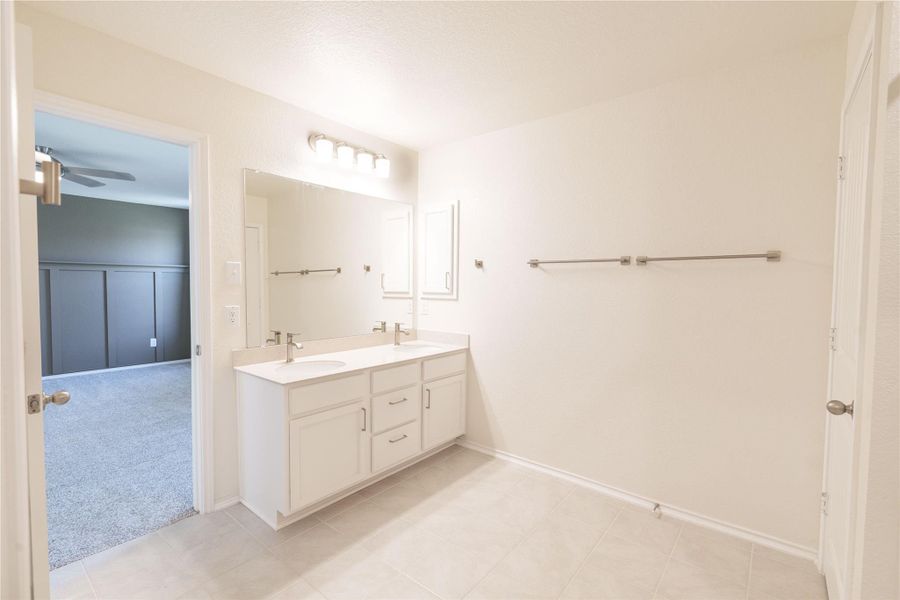 Double vanity sinks and bright lighting adorn this clean and spacious primary bathroom. Double vanity sinks and bright lighting adorn this clean and spacious primary bathroom.