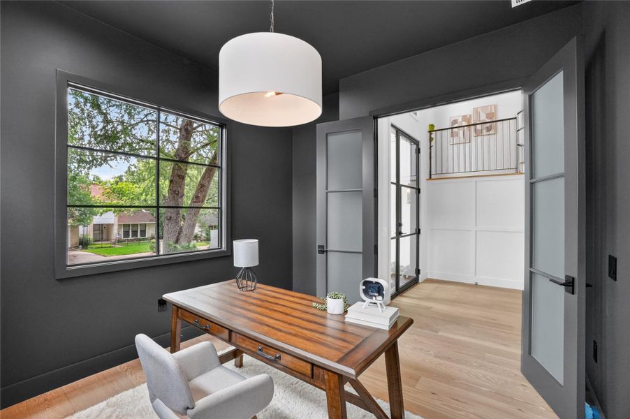 A well-lit study with a view of verdant trees, offering a tranquil work environment.