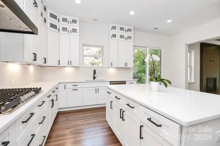 Open floor plan with coffered ceiling, LVP flooring, gas fireplace & open to kitchen and eating area.