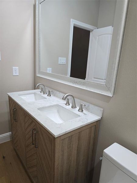 Bathroom featuring toilet, vanity, and hardwood / wood-style floors