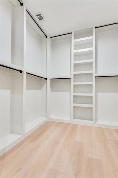 Walk in closet with light wood-style floors