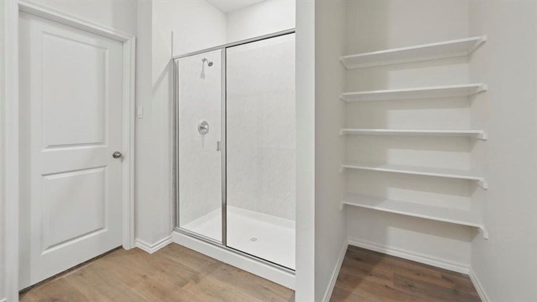 Full bathroom featuring light wood-type flooring and a stall shower