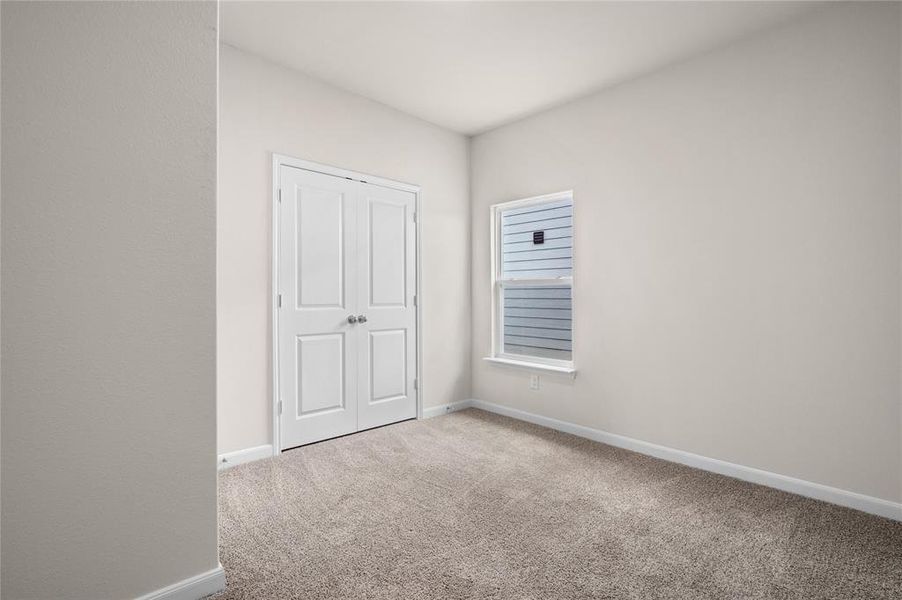 Unfurnished bedroom with light carpet and a closet