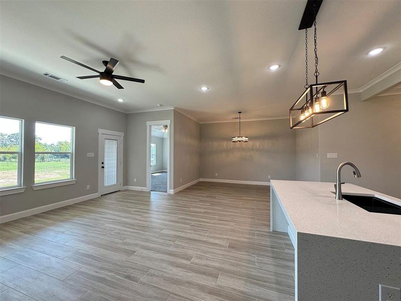 Open concept interior featuring wood-finish flooring, recessed lighting, and crown molding